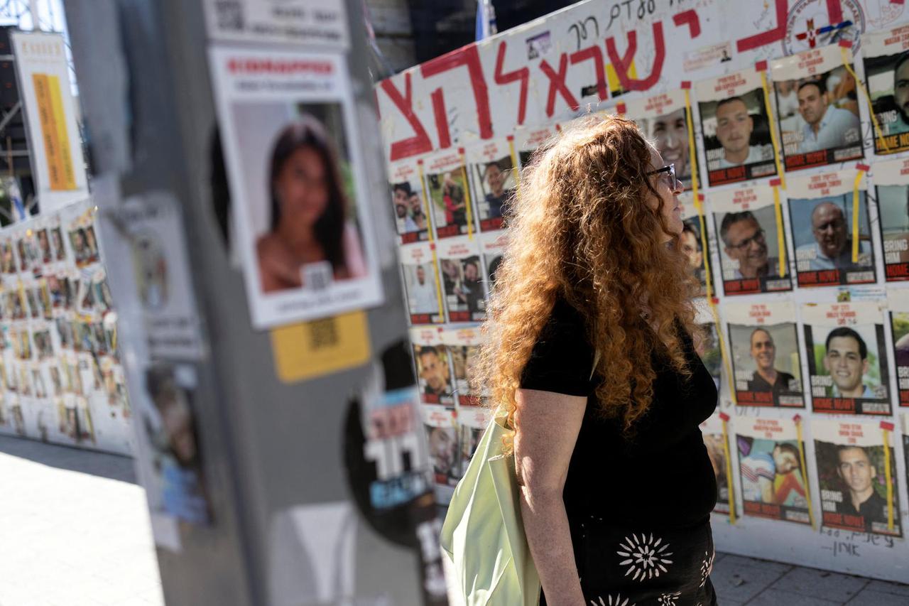 A woman looks at a wall of posters of hostages who were kidnapped during the deadly October 7 attack on Israel by Palestinian Islamist group Hamas