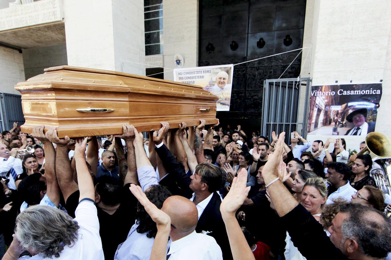 People carries the body of Vittorio Casamonica into a Roman Catholic basilica in a Rome suburb, where the funeral mass was celebrated, August 20, 2015. Casamonica, 65, the head of a notorious Rome crime family, was given a lavish funeral on Thursday, with