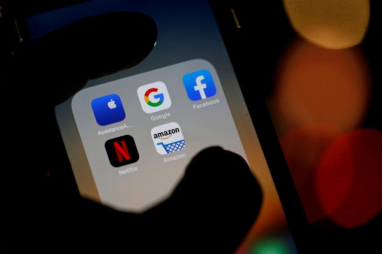 FILE PHOTO: The logos of mobile apps, Google, Amazon, Facebook, Apple and Netflix, are displayed on a screen in this illustration picture