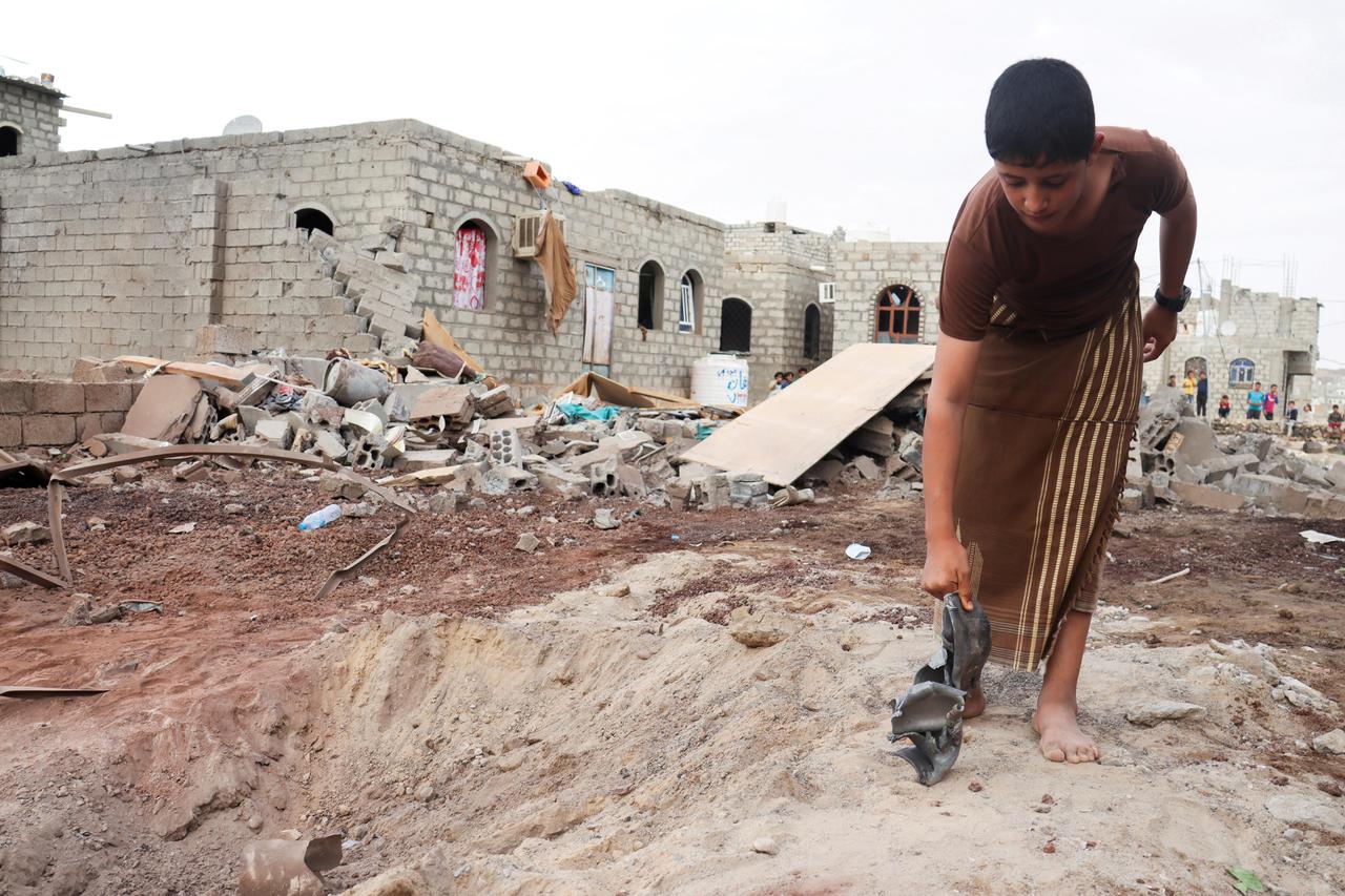 FILE PHOTO: A boy holds shrapnel of a missile at the site of a Houthi missile attack in Marib