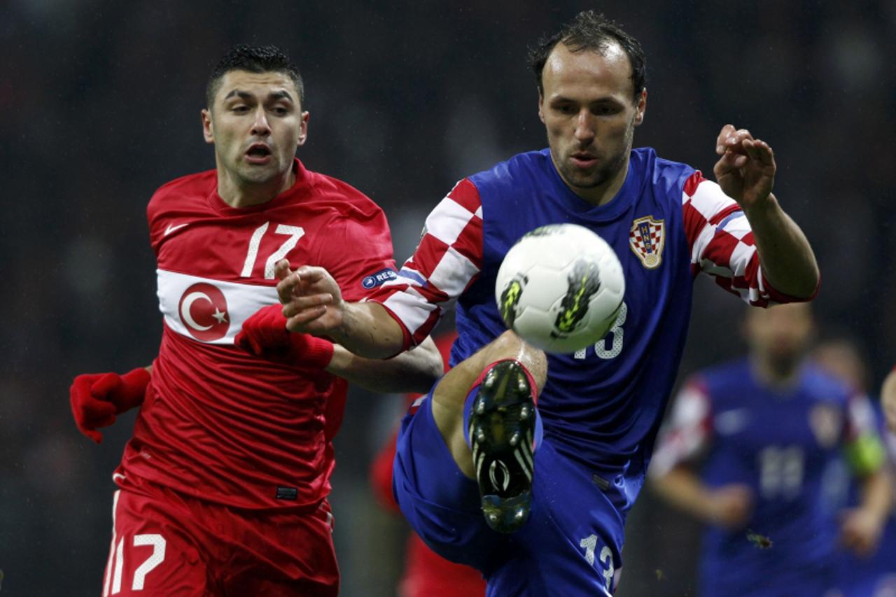 'Turkey\'s Burak Yilmaz (L) challenges Croatia\'s Gordon Schildenfeld (R) during the first leg of their Euro 2012 play-off soccer match at Turk Telekom Arena in Istanbul November 11, 2011. REUTERS/Mur
