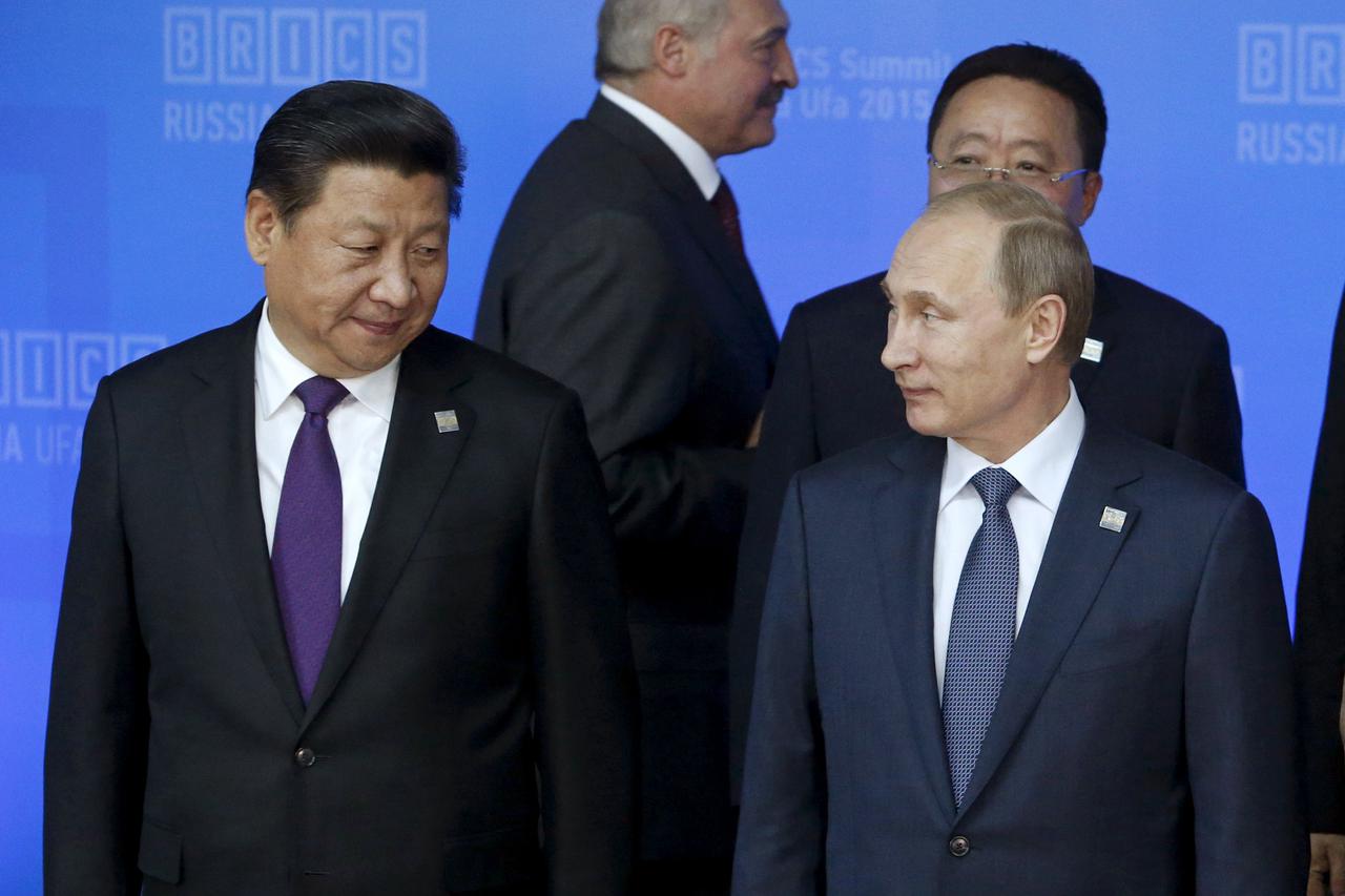 Russia's President Vladimir Putin (R) and China's President Xi Jinping arrive for a family photo session with leaders of the invited states during the BRICS Summit in Ufa, Russia, July 9, 2015. Ufa hosts the BRICS and the Shanghai Cooperation Organization