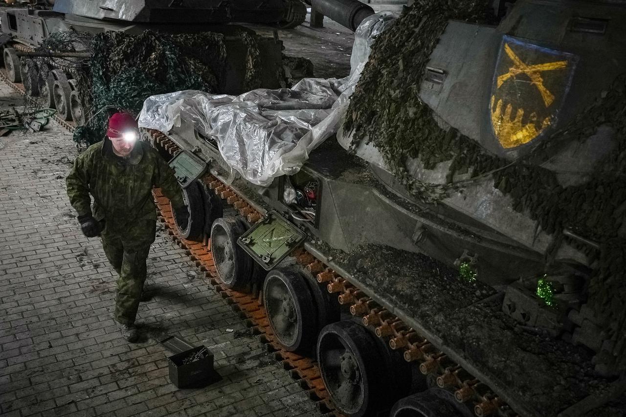 A Ukrainian serviceman repairs a self-propelled howitzer in Donetsk region