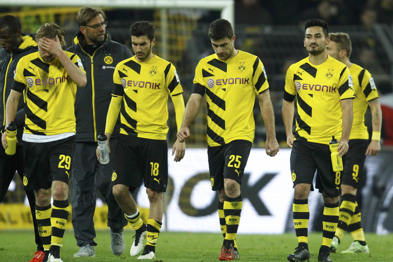 Borussia Dortmund players leave the pitch following their defeat by FC Augsburg in their German first division Bundesliga soccer match in Dortmund February 4, 2015.         REUTERS/Ina Fassbender (GERMANY  - Tags: SPORT SOCCER) DFL RULES TO LIMIT THE ONLI