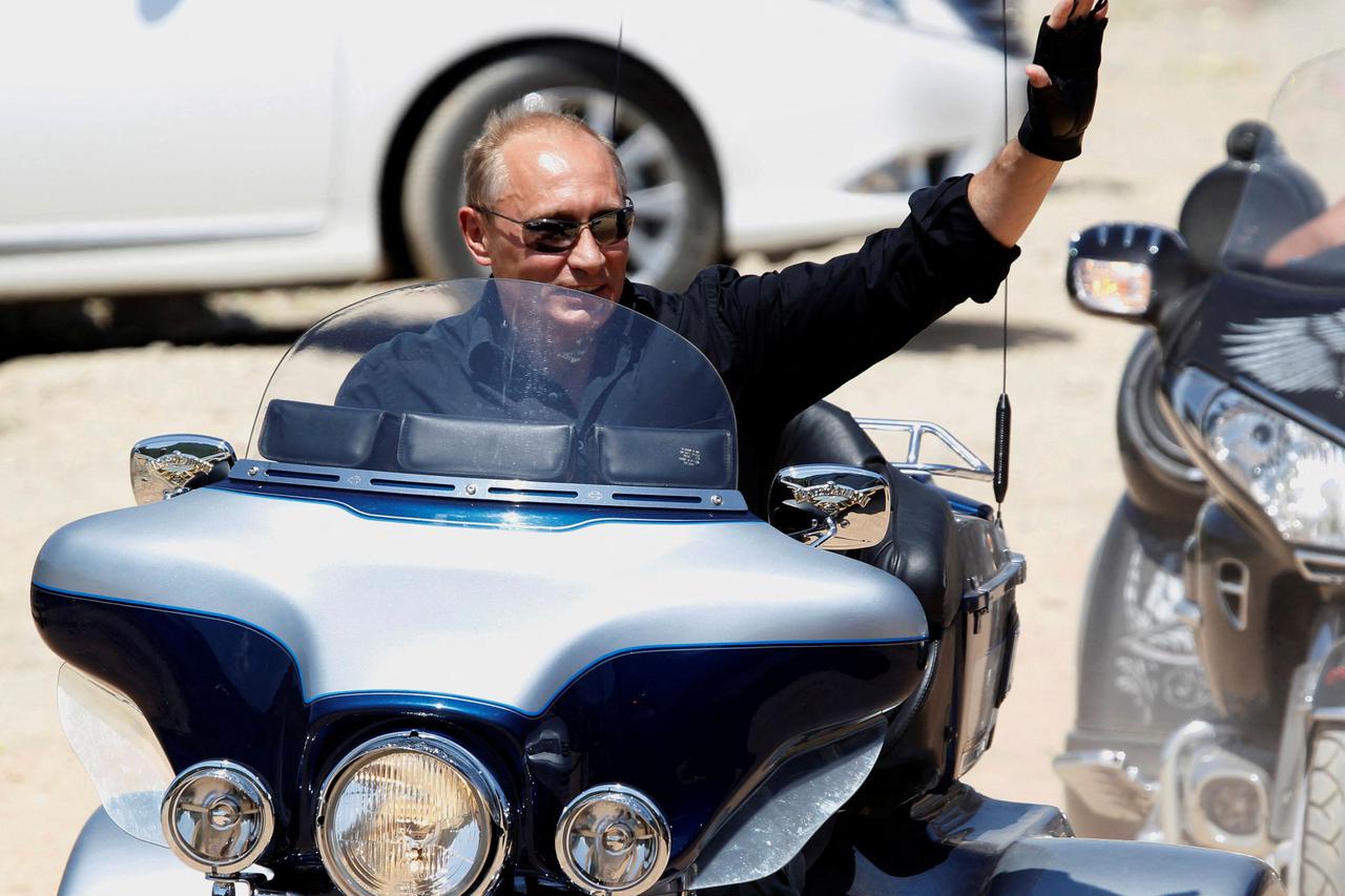 FILE PHOTO: Russia's Prime Minister Vladimir Putin waves while riding a Harley Davidson Lehman Trike near Sevastopol