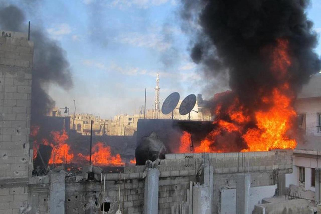 'A handout picture released by Local coordination Committees in Syria (LCC Syria) on February 22, 2012 shows fire on the roof of a building in the Baba Amr neighborhoud of the flashpoint city of Homs,