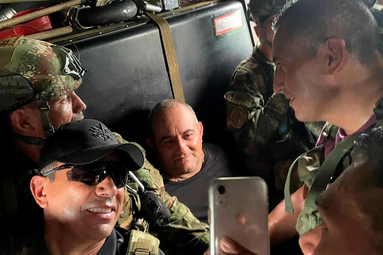 Dairo Antonio Usuga David, alias "Otoniel", top leader of the Gulf clan, poses for a photo while  escorted by Colombian military soldiers inside a helicopter after being captured, in Turbo