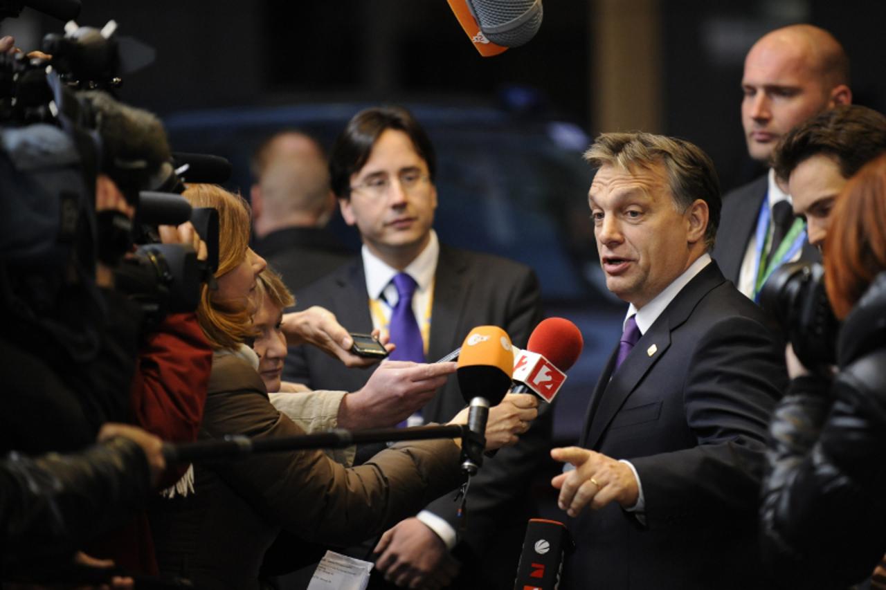 'Hungarian Prime Minister Viktor Orban (R) talks to the press as he arrives at the EU Headquarters on November 22, 2012 in Brussels, to take part in a two-day European Union leaders summit called to a
