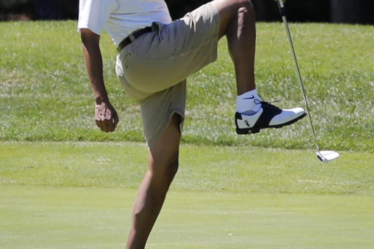 'U.S. President Barack Obama reacts after missing a putt on the first green at the Farm Neck Golf Club at Oak Bluffs on Marthas Vineyard, August 11, 2013.      REUTERS/Larry Downing  (UNITED STATES - 