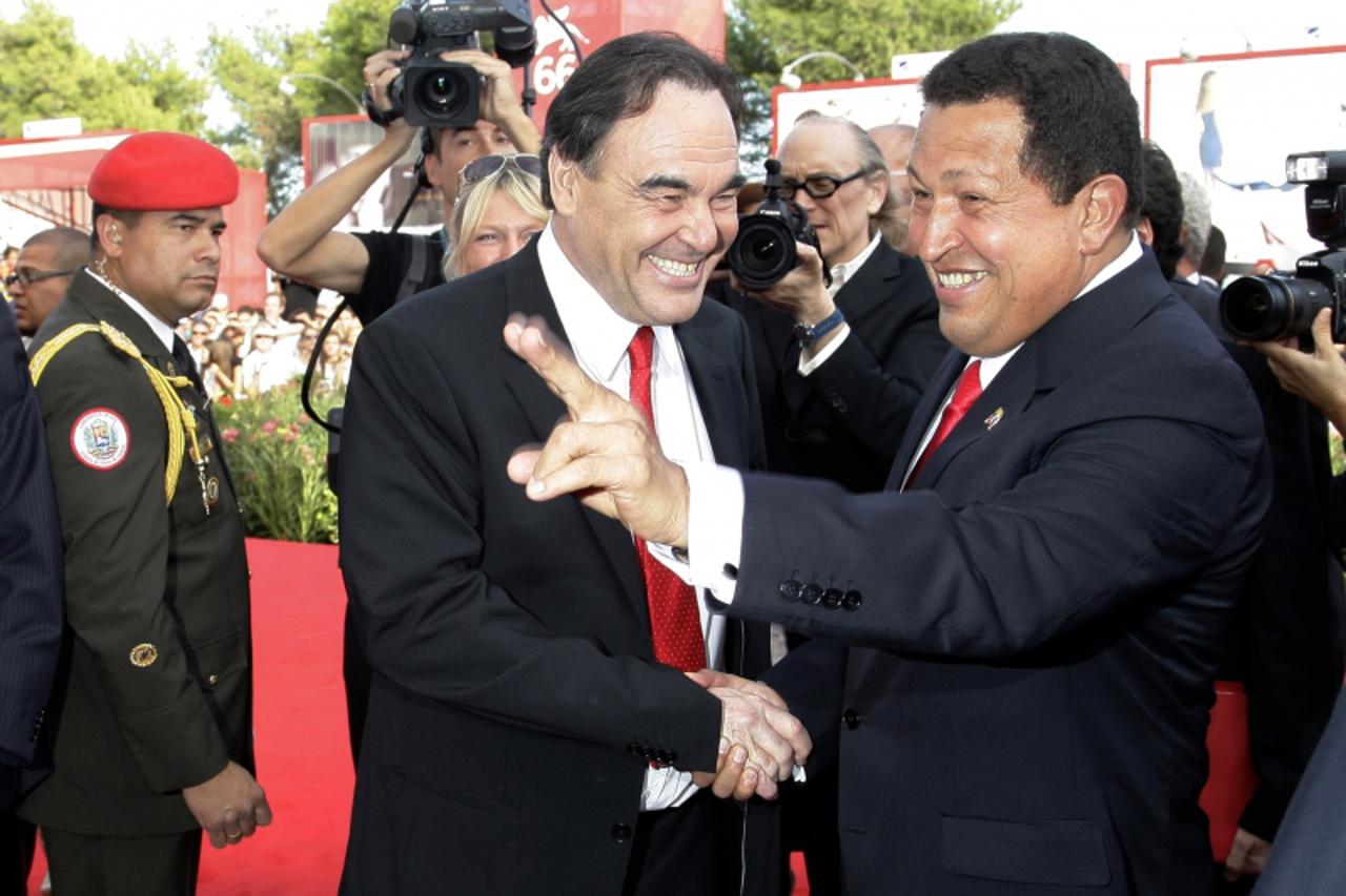 'U.S. film director Oliver Stone (L) and Venezuela\'s President Hugo Chavez pose for photographers during a red carpet at the 66th Venice Film Festival September 7, 2009. REUTERS/Tony Gentile (ITALY E