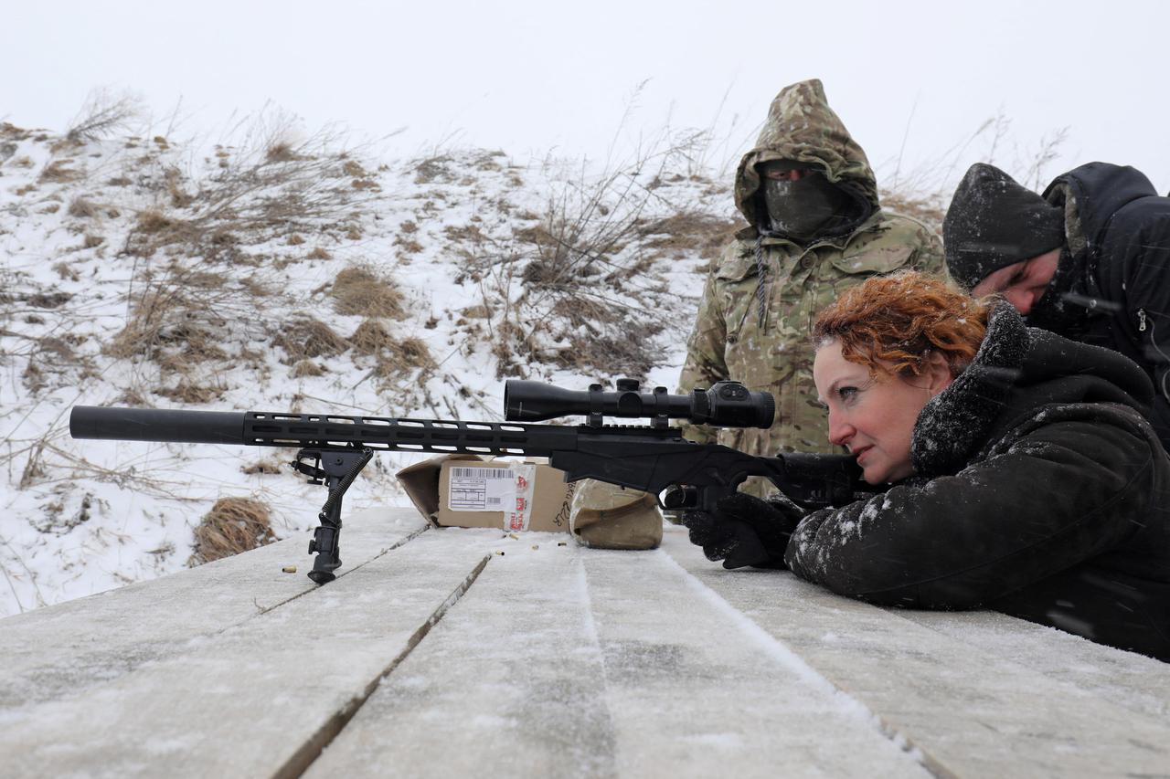 Employees of essential city industries and services attend a military training session outside Lviv