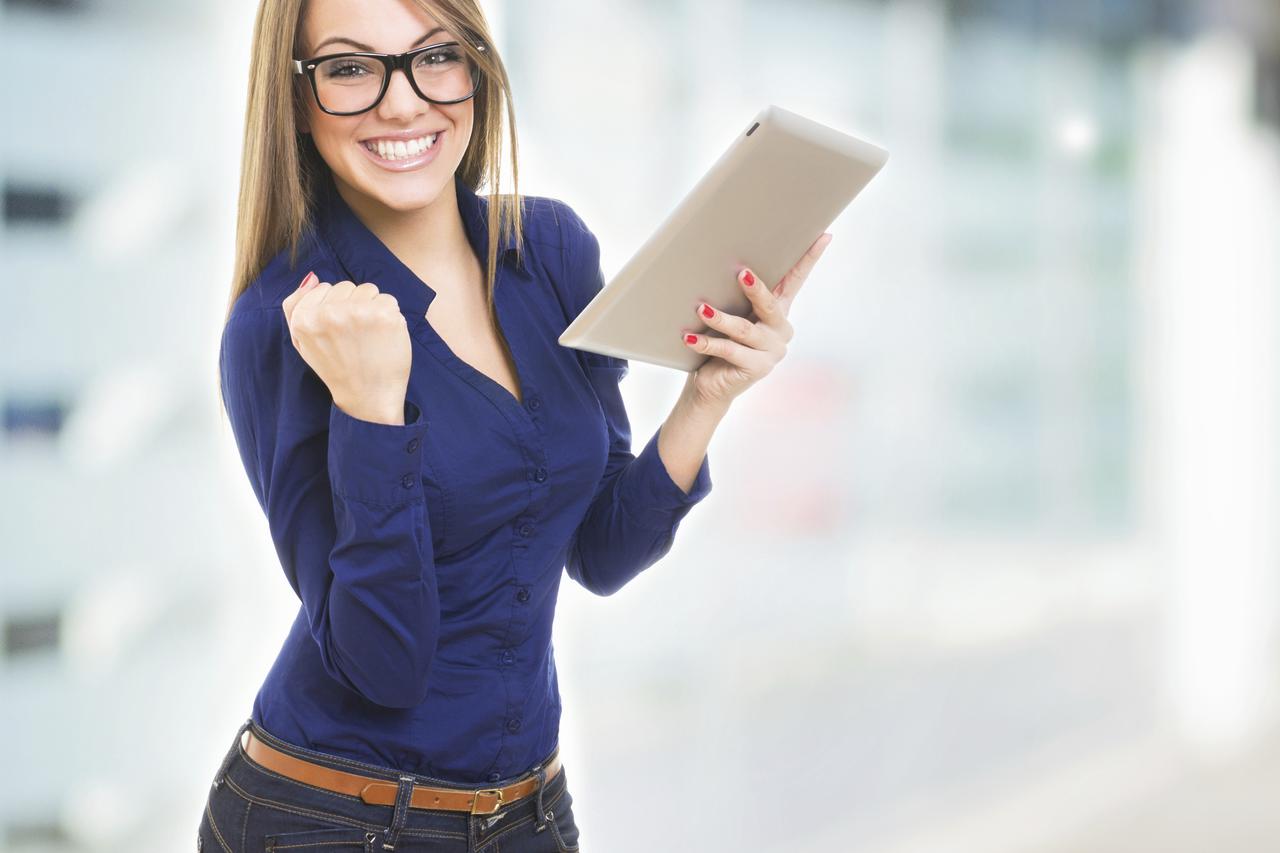 Excited happy young woman wearing glasses with tablet computer