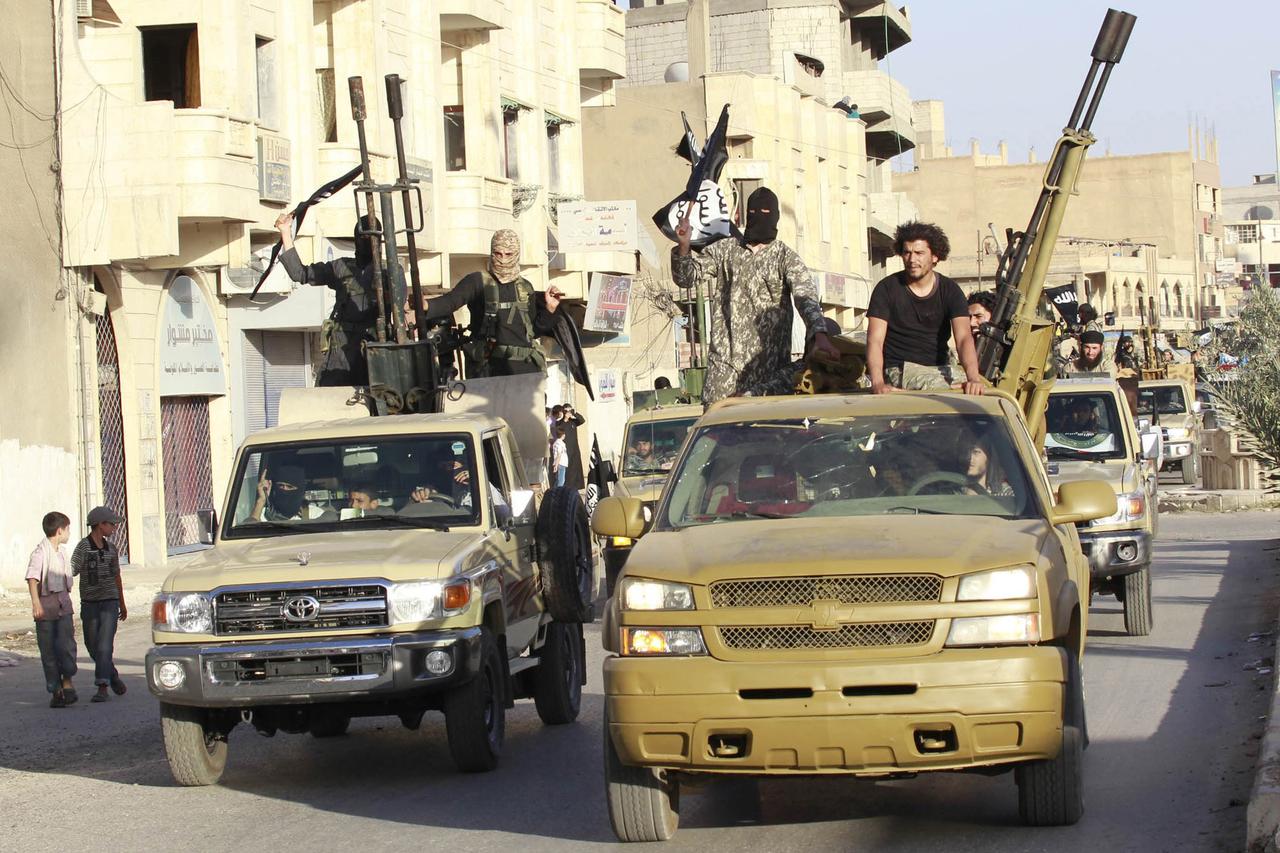 Militant Islamist fighters in military vehicles parade along the streets of Syria's northern Raqqa province June 30, 2014. The fighters held the parade to celebrate their declaration of an Islamic 