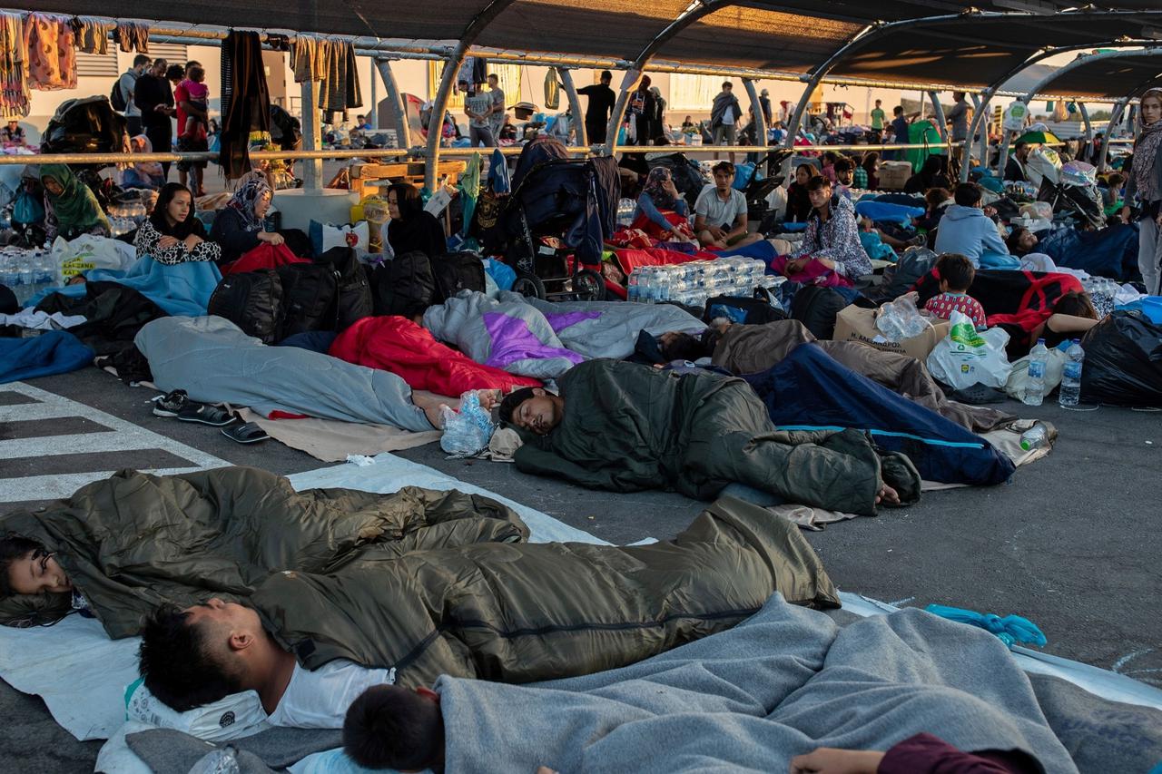 Refugees and migrants sleep at the parking of a supermarket, following a fire at the Moria camp on the island of Lesbos