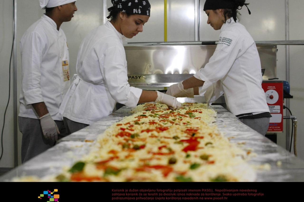Workers prepare a 15-meter pizza for the 2nd edition of the Expo Pizzeria Fair, on the occasion of the Pizza Day, in Sao Paulo, Brazil, on July 10, 2012. After the event, the giant pizza will be donat