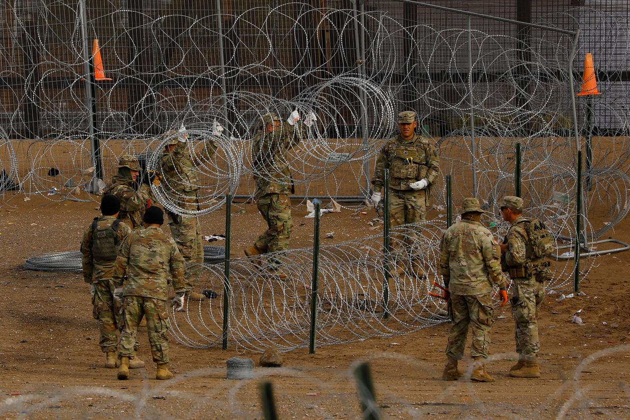 Texas National Guard members place razor wire near U.S.-Mexico border fence, as seen from Ciudad Juarez