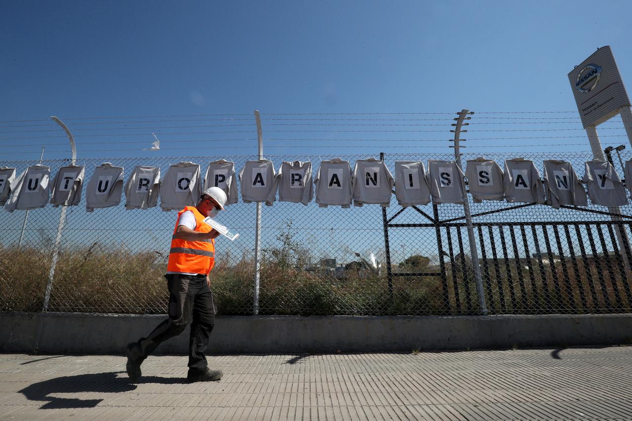A man walks past shirts hanging from a fence with sings reading "Future for Nissan, now" at Nissan factory at Zona Franca during the coronavirus disease (COVID-19) outbreak in Barcelona