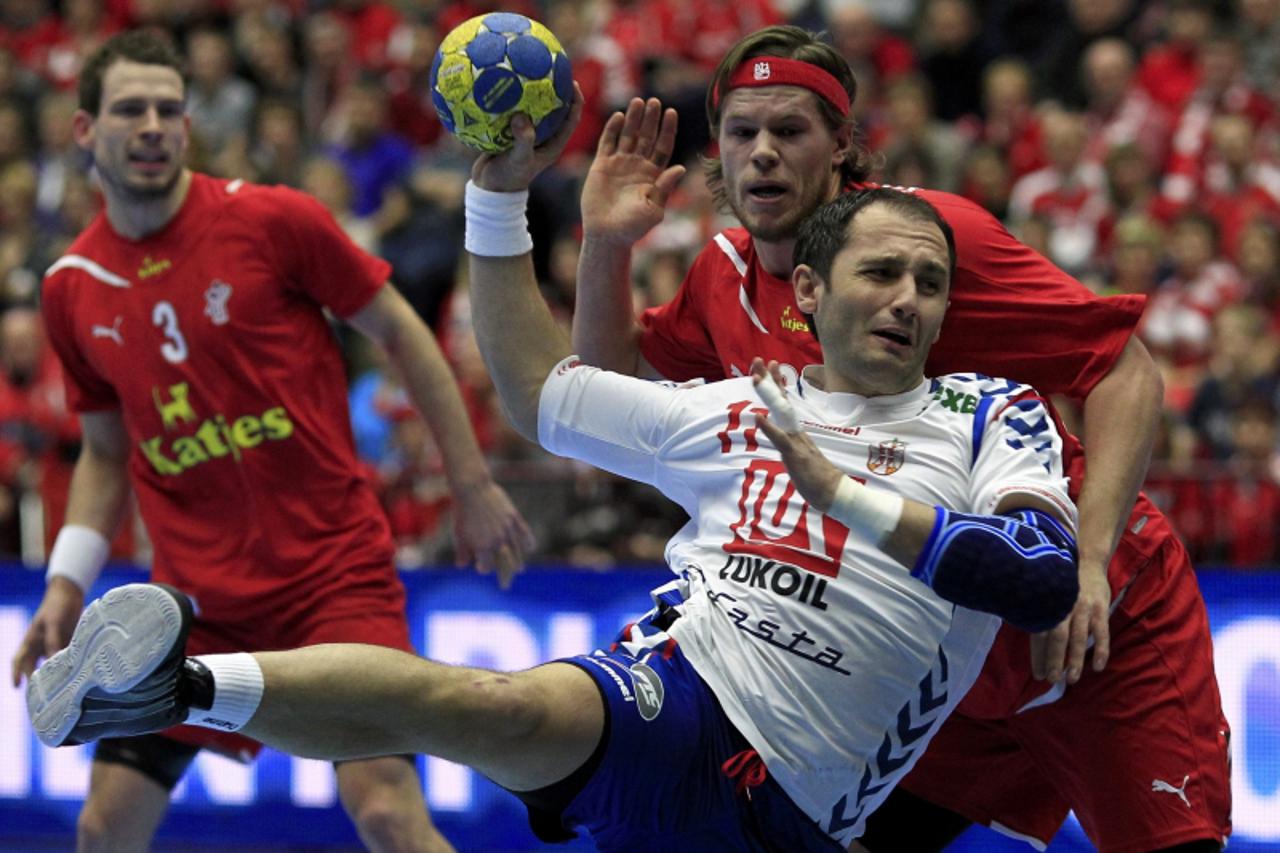 \'Serbia\'s Alem Toskic (R) attempts to score next to Denmark\'s Mikkel Hansen and Mads Christiansen (L) during their group C match at the Men\'s Handball World Championship in Malmo January 17, 2011.