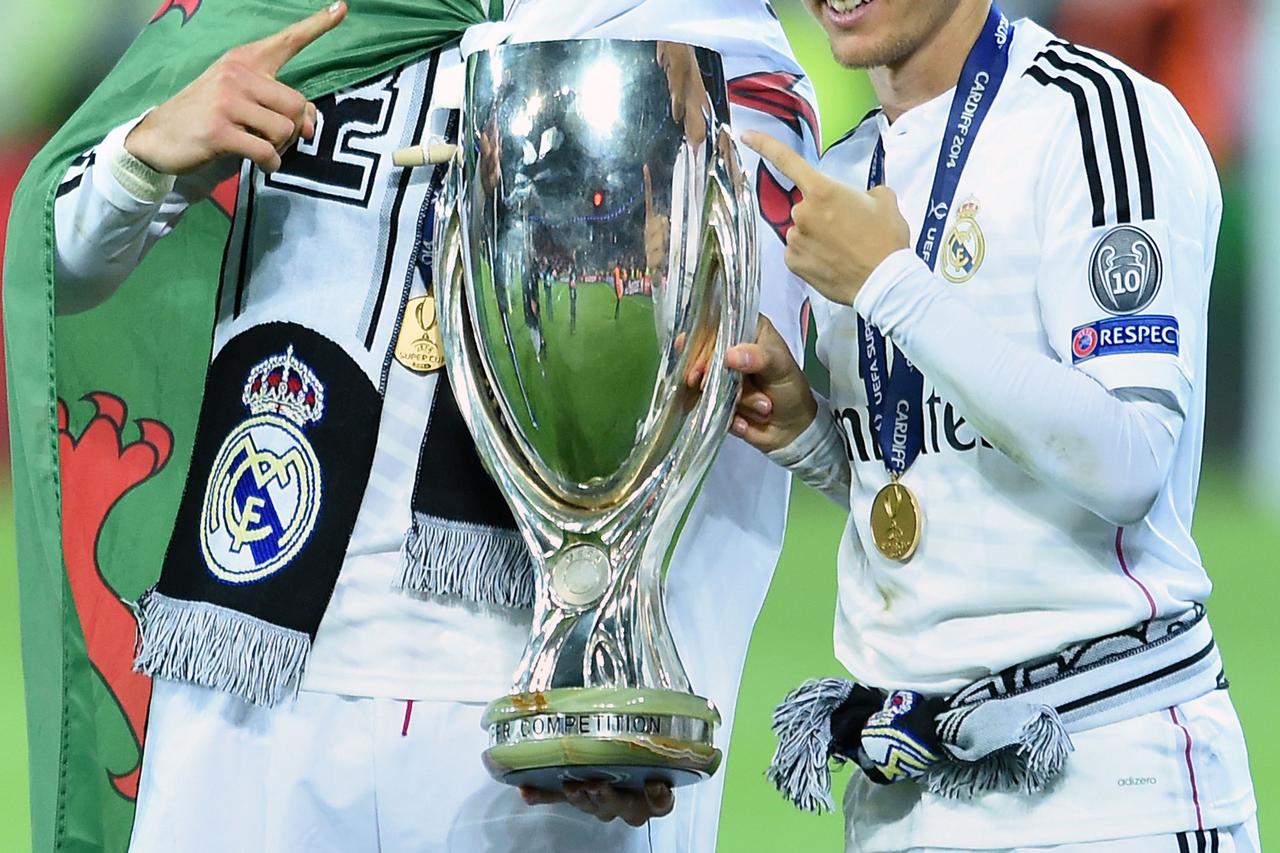 Soccer - 2014 UEFA Super Cup - Sevilla v Real Madrid - Cardiff City StadiumReal Madrid's Gareth Bale (left) and Luka Modric (right) with the trophy after winning the UEFA Super Cup Final at the Cardiff City Stadium, Cardiff.Joe Giddens Photo: Press Associ