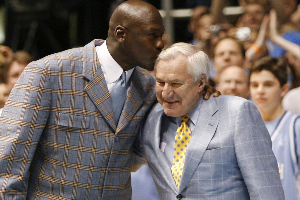 Former University of North Carolina player and NBA standout Michael Jordan (L) kisses former University of North Carolina head coach Dean Smith during a ceremony honoring the 1957 and 1982 national championship teams at halftime of the NCAA basketball gam