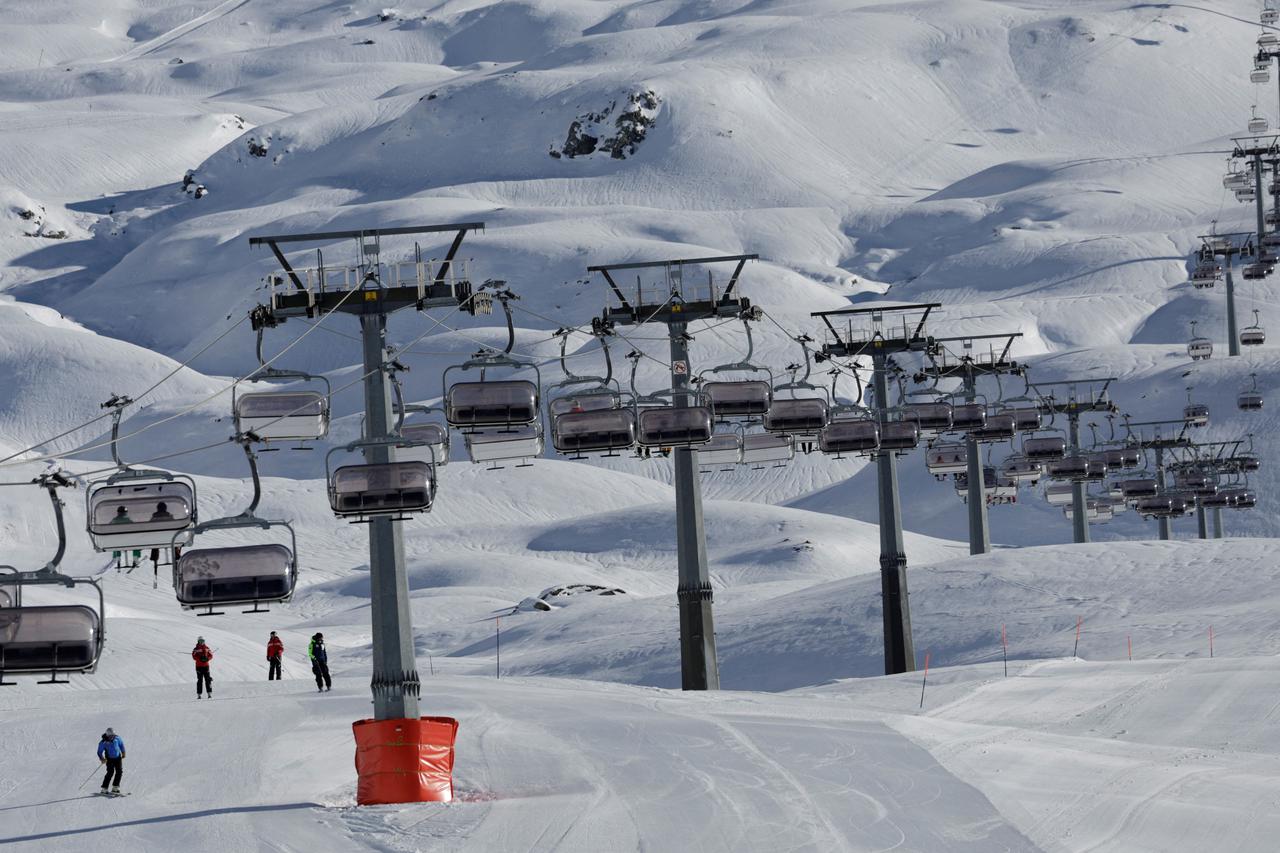 Skiers use a chair lift next to the slope in the ski resort of Breuil-Cervinia