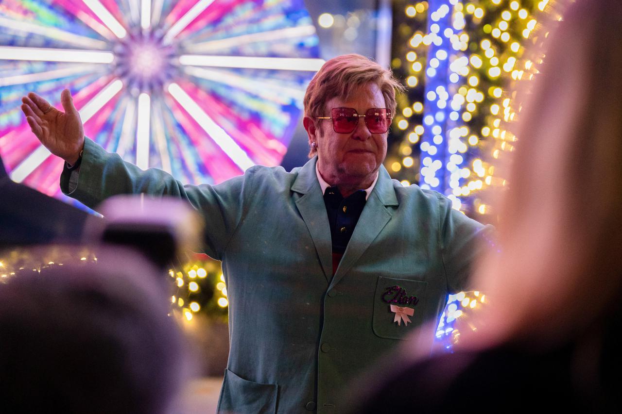 Singer Sir Elton John poses for photos after a performance at  an event to unveil the 2022 holiday windows displays at Saks 5th Avenue department store in New York City
