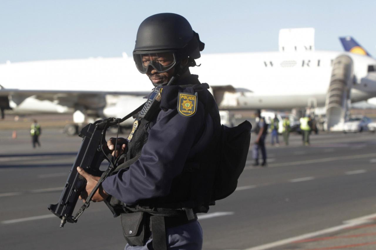 'A policeman stands guard while South Korean national soccer team players  arrive at Johannesburg\'s O.R. Tambo airport June 5, 2010. The 2010 FIFA Soccer World Cup kicks off on June 11.  REUTERS/Henr