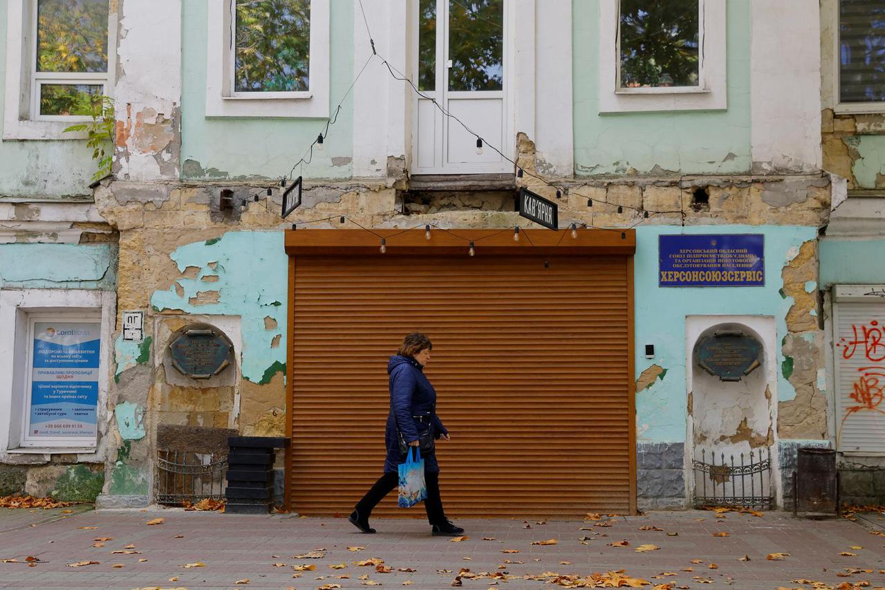 A woman walks along a street in Kherson