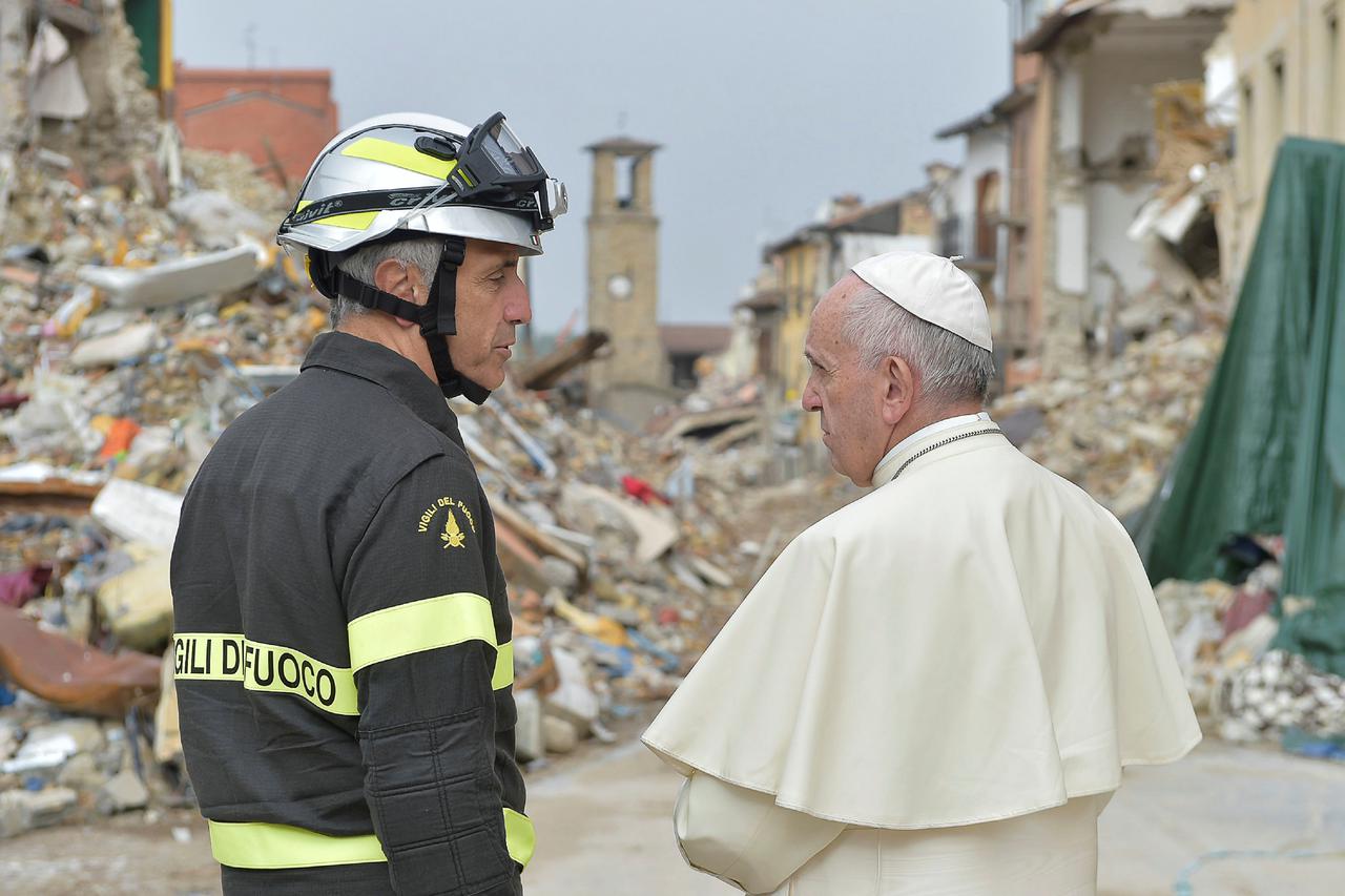 Pope Francis talks with a firefighter in Amatrice, Italy, October 4, 2016. REUTERS/Osservatore Romano/Handout via Reuters