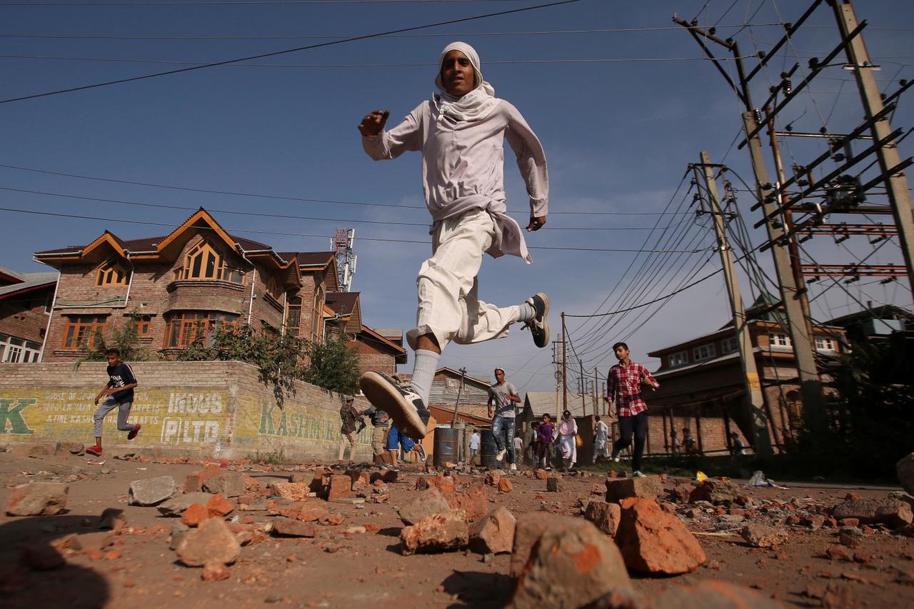 FILE PHOTO: Kashmiris run for cover as Indian security forces fire teargas shells during clashes, after scrapping of the special constitutional status for Kashmir by the Indian government, in Srinagar