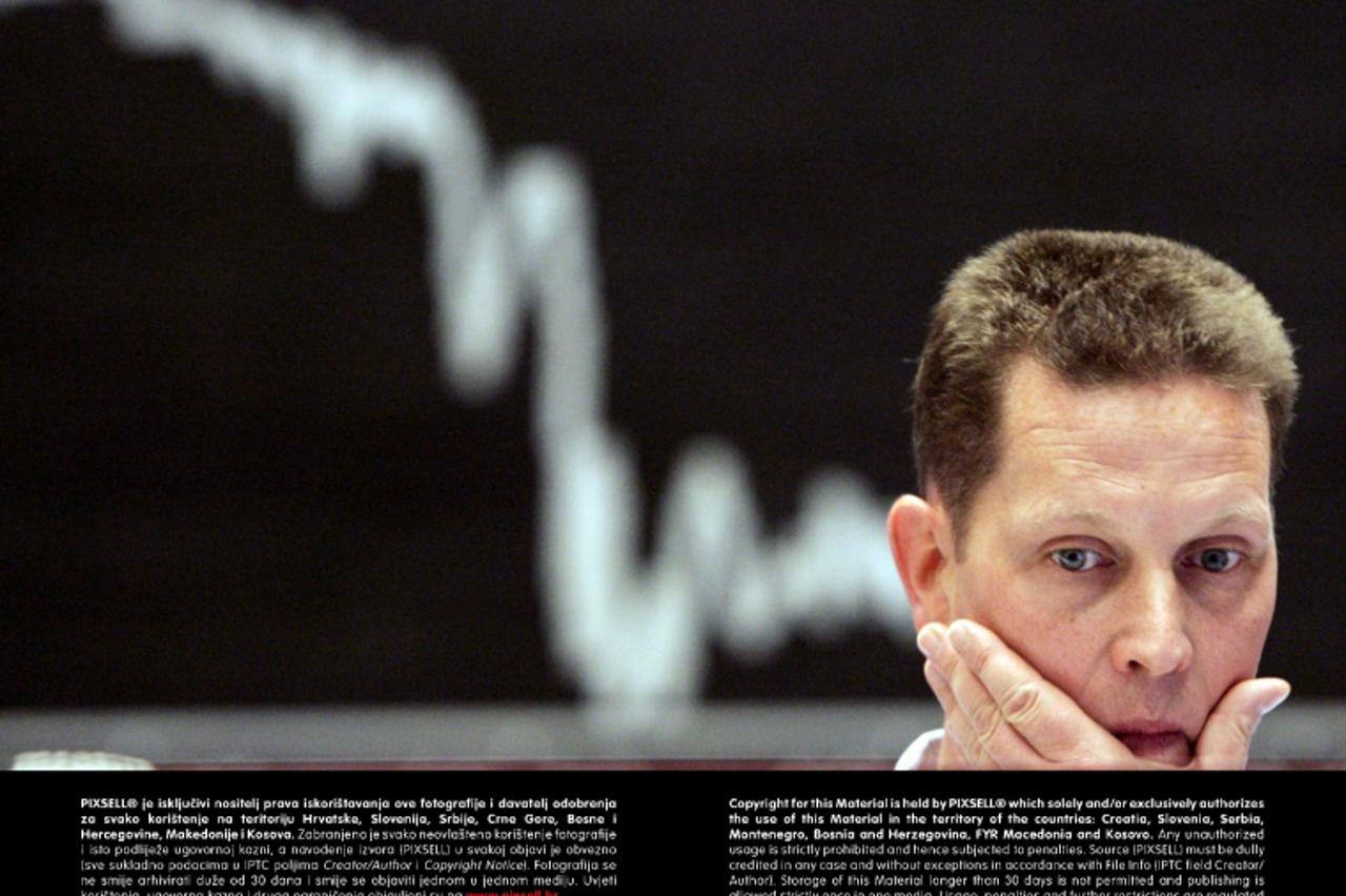 'Ein Börsenhändler fasst sich am Donnerstag (07.07.2005) auf dem Parkett der Frankfurter Wertpapierbörse vor der Anzeigentafel für den Deutschen Aktienindex (DAX) ins Gesicht. Nachdem Nachrichtensende