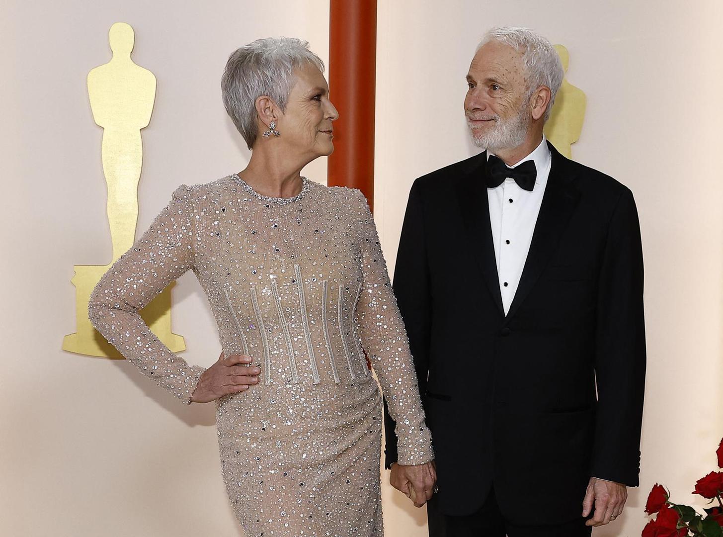 Jamie Lee Curtis and her husband Christopher Guest pose on the champagne-colored red carpet during the Oscars arrivals at the 95th Academy Awards in Hollywood, Los Angeles, California, U.S., March 12, 2023. REUTERS/Eric Gaillard Photo: ERIC GAILLARD/REUTERS