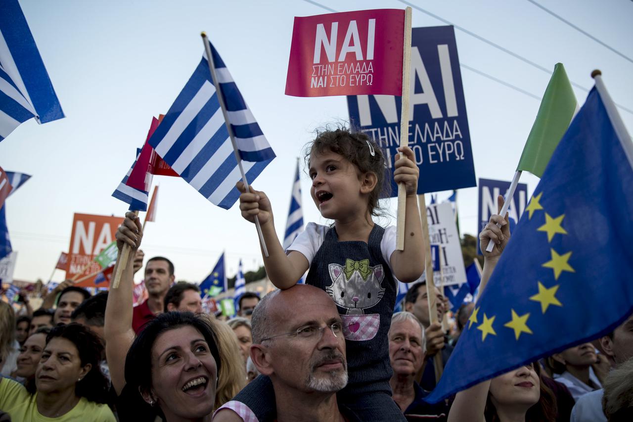 A 'Yes' supporter wave Greek flags during a pro-Euro rally at the Panathenean stadium in Athens, Greece, July 3, 2015. An opinion poll on Greece's bailout referendum published on Friday pointed to a slight lead for the Yes vote, on 44.8 percent, against 4