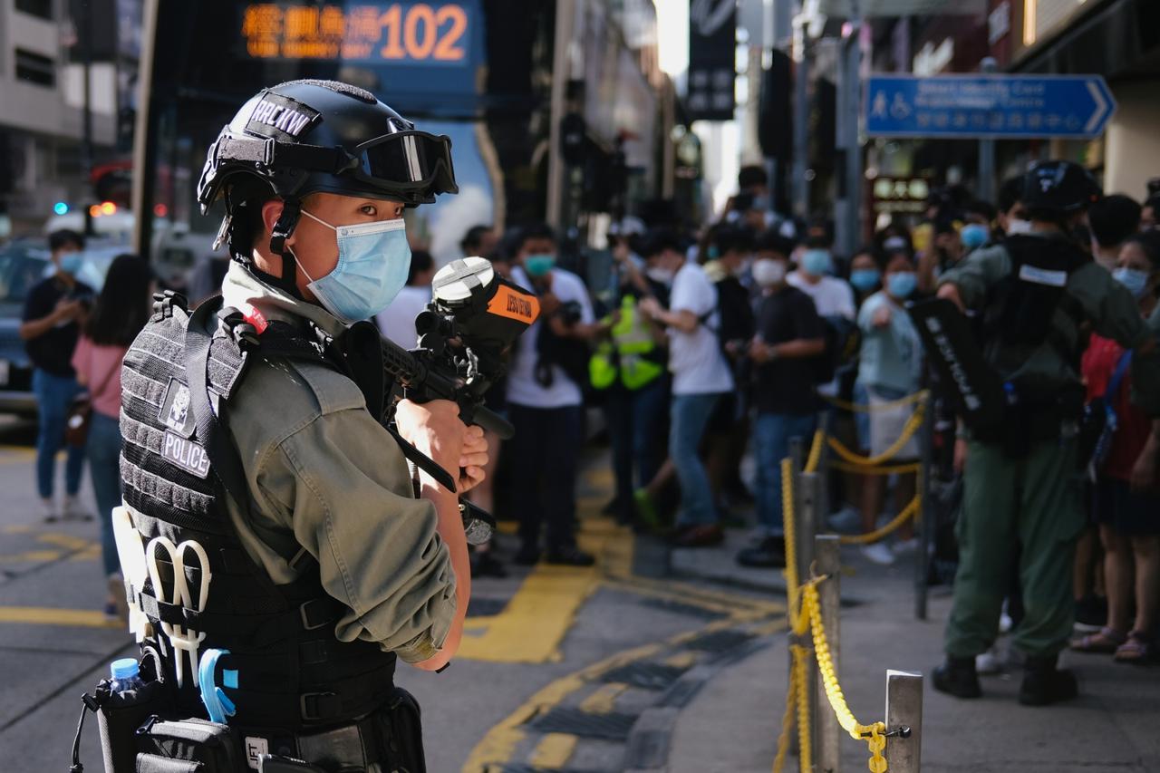 A riot police officer holds a pepper-spray projectile as he stands guard to avoid mass gathering during a protest against the looming national security legislation in Hong Kong