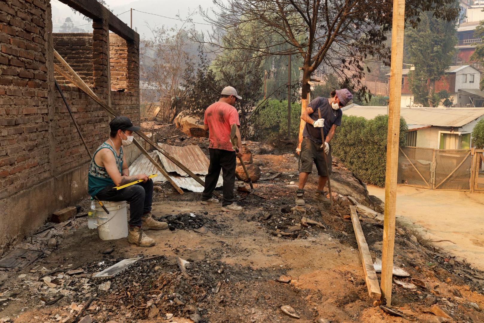 People work amongst the remains of burnt houses following the spread of wildfires in Vina del Mar, Chile February 3, 2024. REUTERS/Sofia Yanjari Photo: SOFIA YANJARI/REUTERS