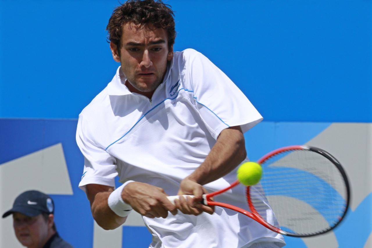 'Marin Cilic of Croatia returns the ball to Arnaud Clement of France during their tennis match at the Queen\'s Club Championships in west London June 8, 2011.  REUTERS/Suzanne Plunkett (BRITAIN - Tags