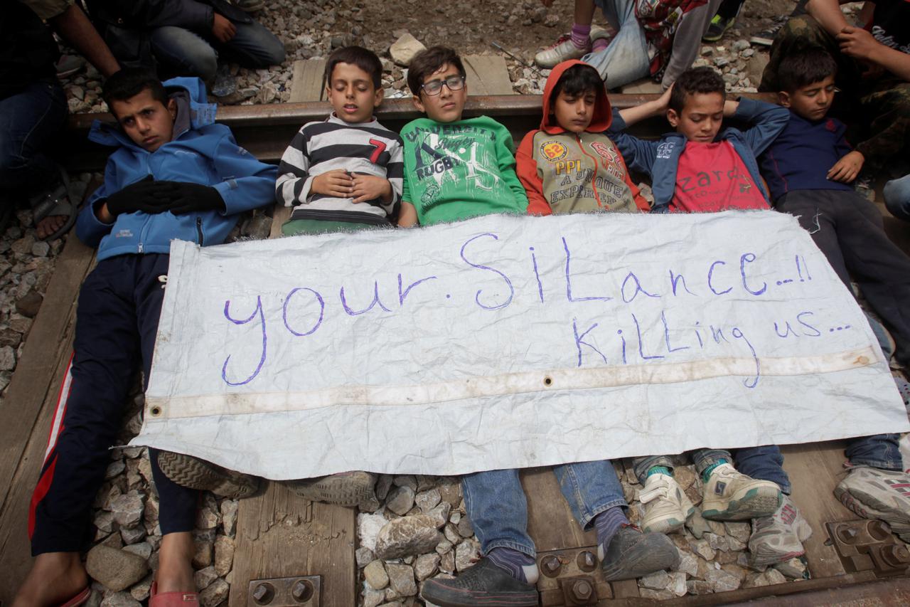 Boys lay on a railway track during a protest at a makeshift camp for refugees and migrants at the Greek-Macedonian border near the village of Idomeni Boys lay on a railway track during a protest at a makeshift camp for refugees and migrants at the Greek-M