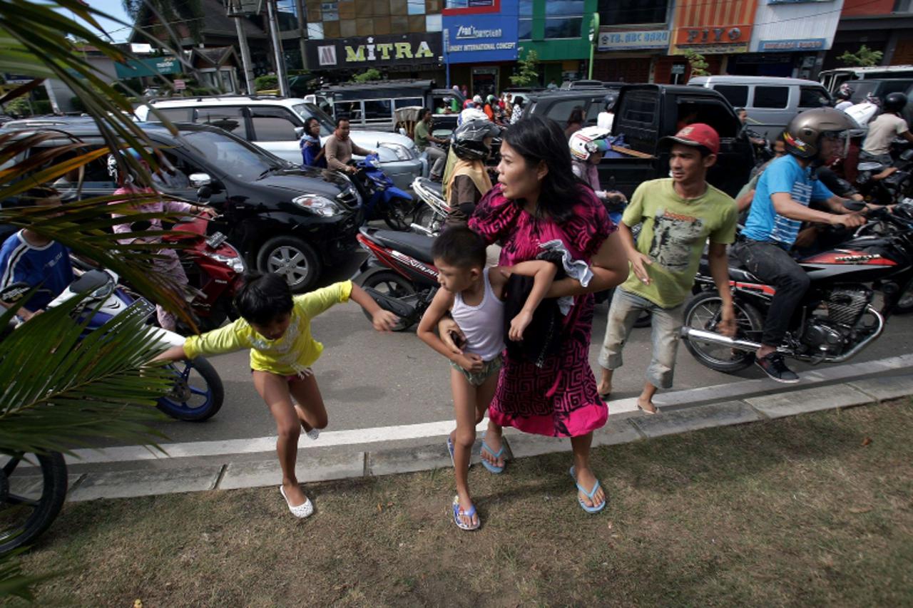 'Acehnese people run shortly after a powerfull earthquake hit western coast of Sumatera in Banda Aceh on April 11, 2012.  A massive earthquake struck off Indonesia\'s Sumatra island, US and Indonesian