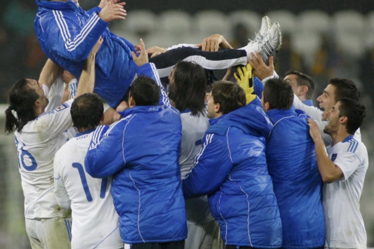 'Greece\'s players throw their coach Otto Rehhagel in the air after their 2010 World Cup qualifying soccer match against Ukraine in Donetsk November 18, 2009 November 18, 2009. REUTERS/Gleb Garanich (