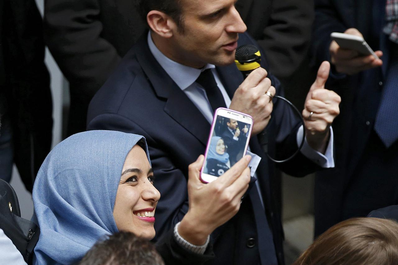 A woman takes a selfie as Emmanuel Macron, head of the political movement En Marche ! (or Onwards !) and candidate for the 2017 presidential election, visits the university of Lille, France, March 14, 2017.  REUTERS/Charles Platiau
