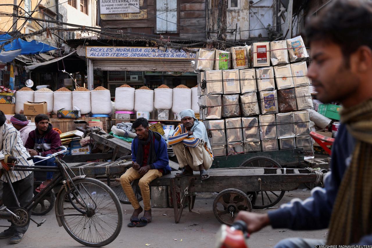FILE PHOTO: Workers sit on a cart at a wholesale market in the old quarters of Delhi