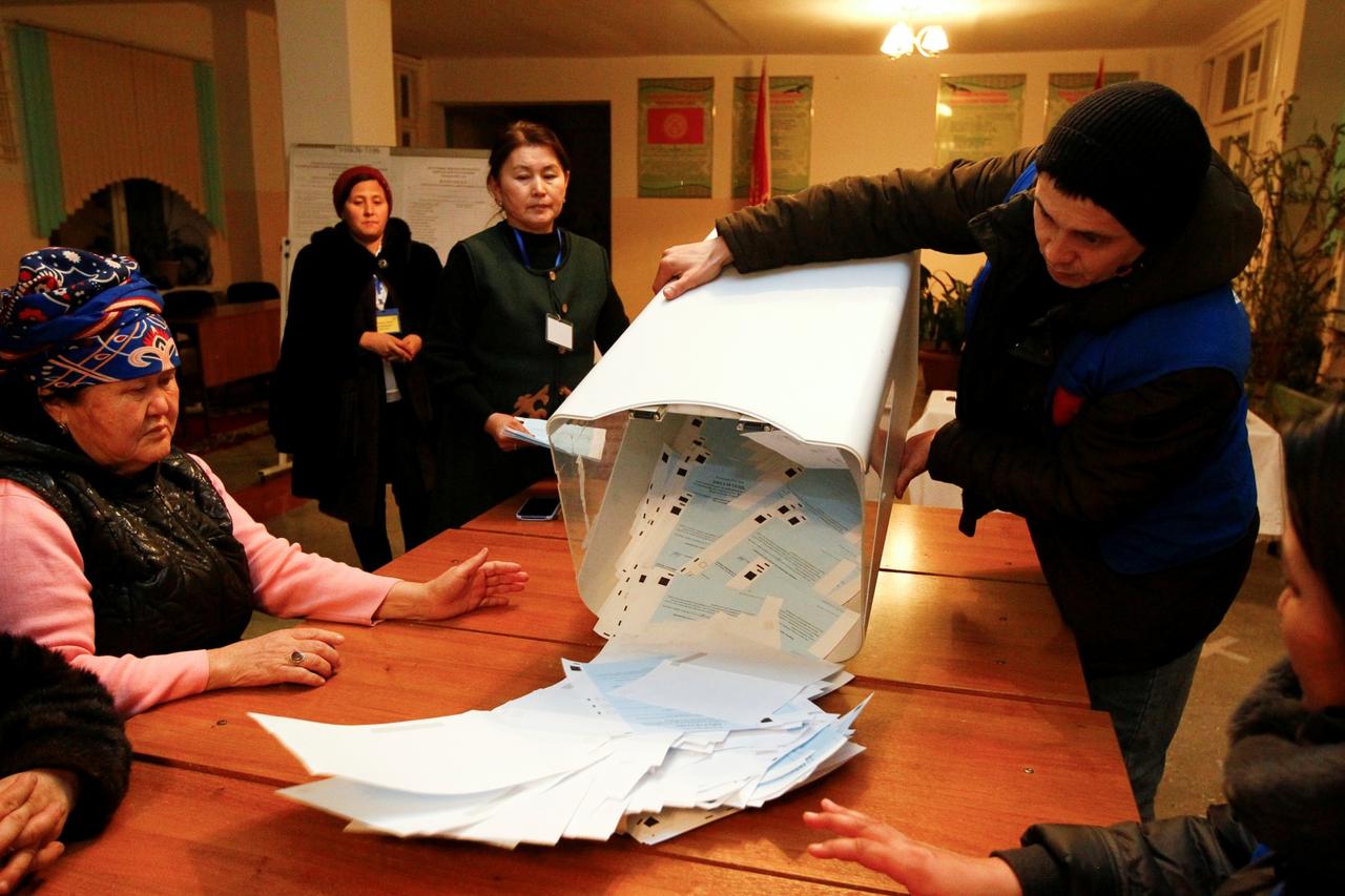 Members of a local electoral commission empty a ballot box after polls closed during a presidential election and constitutional referendum in Arashan