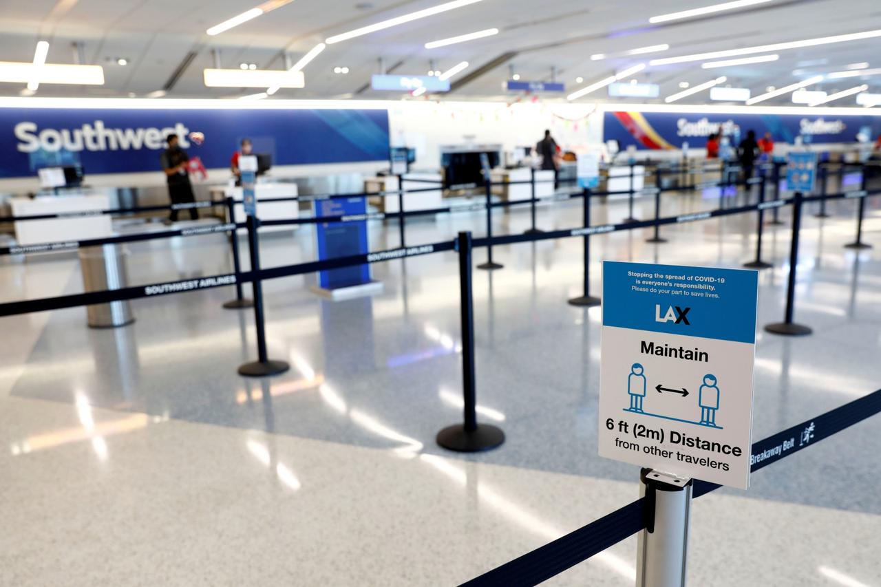 FILE PHOTO: Social distancing sign is displayed at a check-in area for Southwest Airlines Co. at Los Angeles International Airport (LAX) on an unusually empty Memorial Day weekend during the outbreak of the coronavirus disease (COVID-19) in Los Angeles