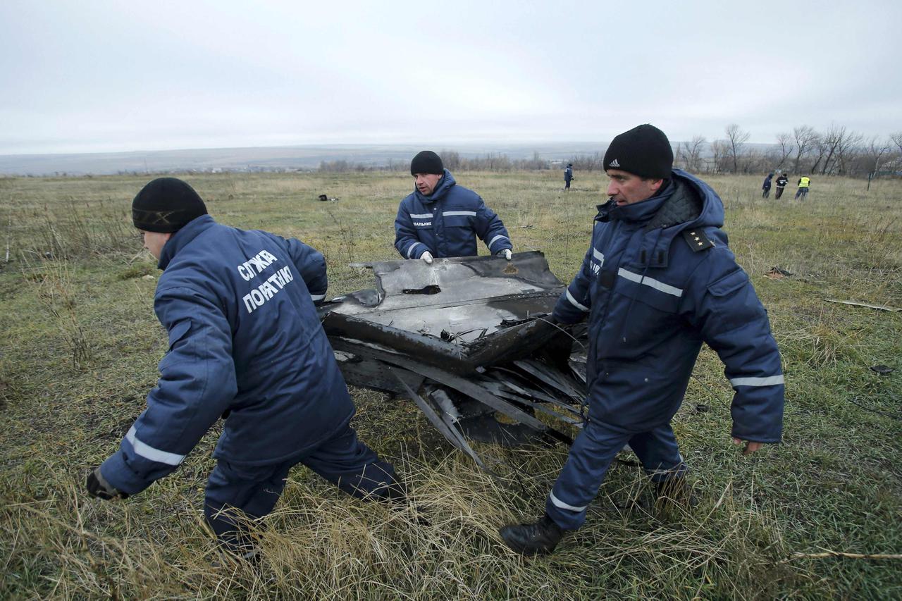 Local workers carry wreckage of the Malaysia Airlines Boeing 777 plane (flight MH17) at the site of the plane crash near the settlement of Grabovo in the Donetsk region November 16, 2014. Local emergency services have begun collecting parts of the wreckag