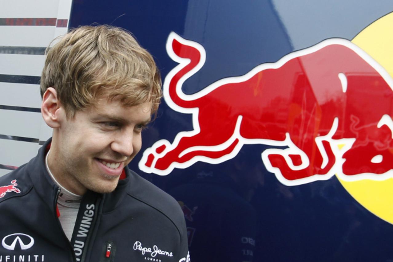 'Red Bull Formula One driver Sebastian Vettel of Germany smiles on the paddock during a training session at Circuit de Catalunya racetrack, in Montmelo, near Barcelona, March 4, 2012. REUTERS/Albert G