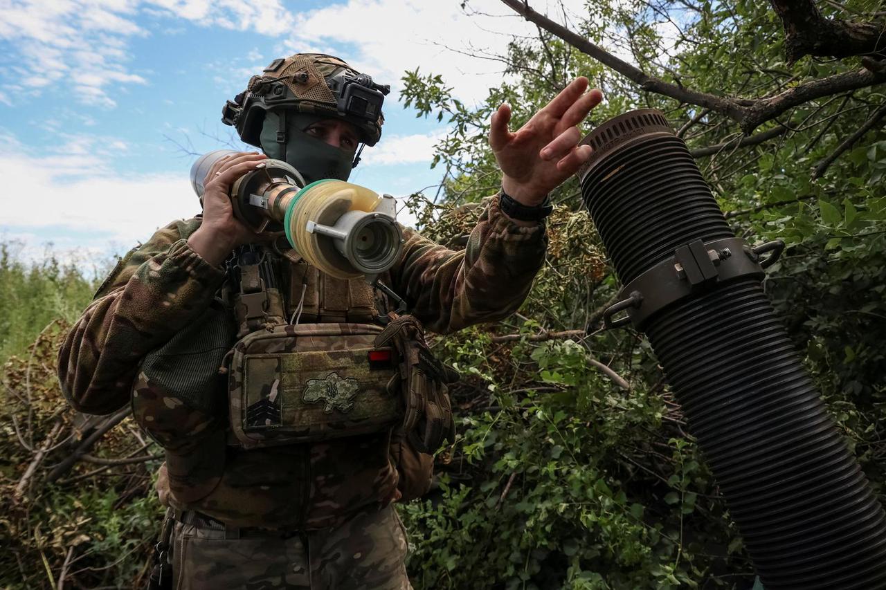 Ukrainian service members fire a mortar at a front line near the city of Bakhmut
