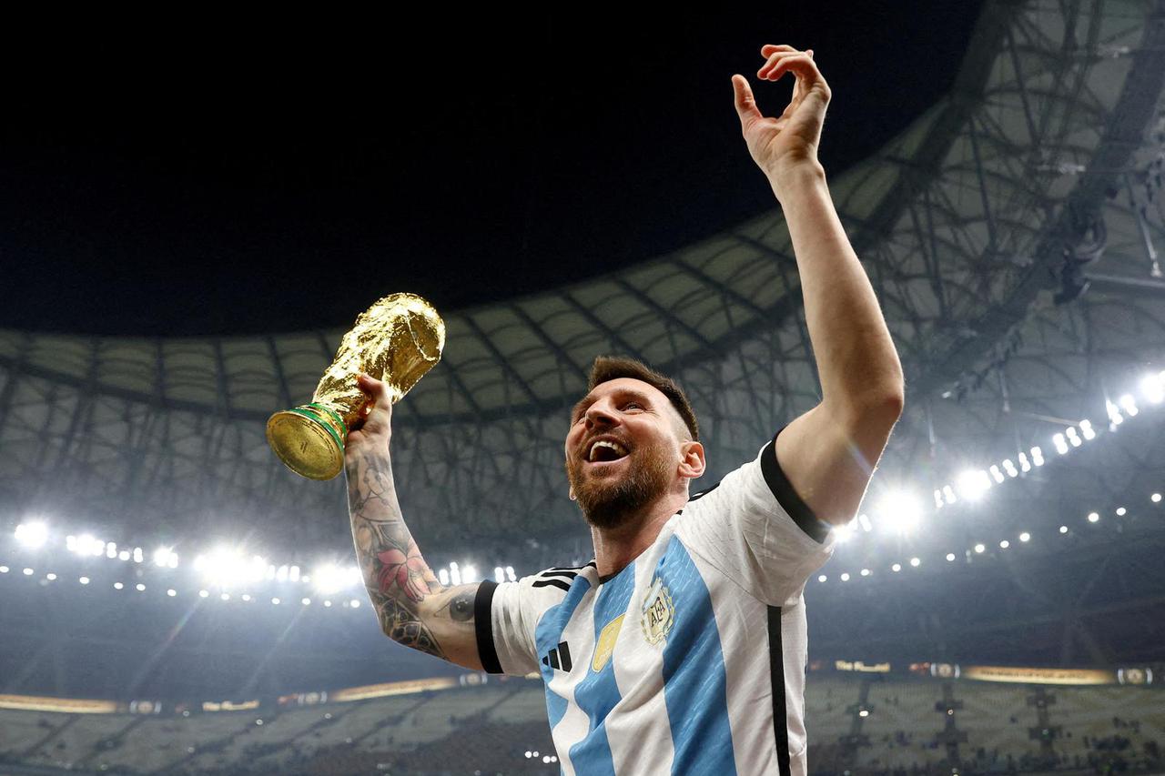 FILE PHOTO: Argentina's Lionel Messi celebrates winning the World Cup with the trophy, Lusail, Qatar - December 18, 2022