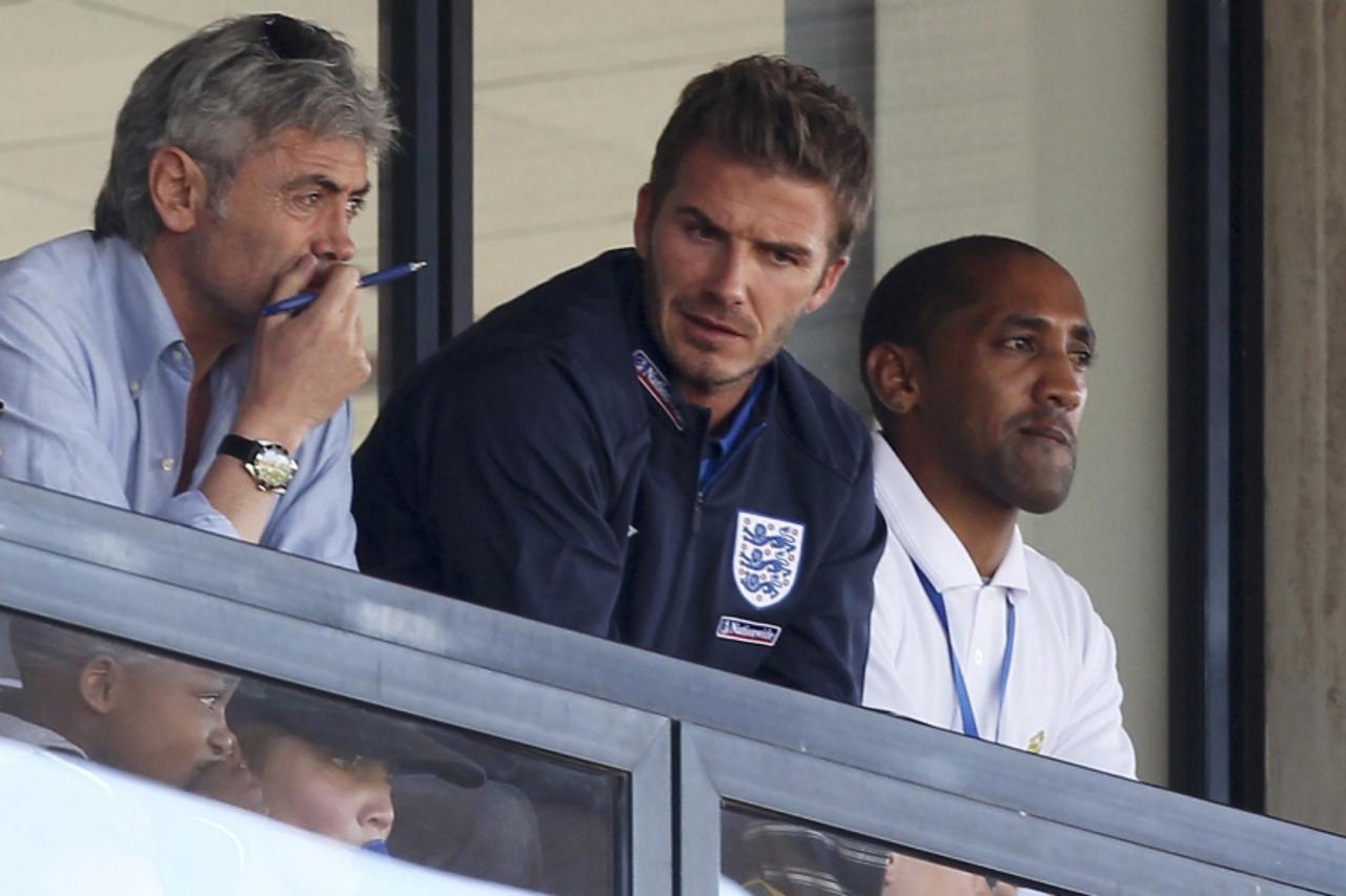 'England\'s injured midfielder David Beckham watches the friendly soccer match betweeen Australia and the U.S. at the Ruimsig stadium in Roodepoort, just outside of Johannesburg June 5, 2010. The 2010