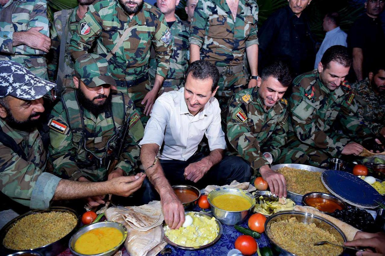 Syria's president Bashar al-Assad (C) joins Syrian army soldiers for Iftar in the farms of Marj al-Sultan village, eastern Ghouta in Damascus, Syria, in this handout picture provided by SANA on June 26, 2016. SANA/Handout via REUTERS TPX IMAGES OF THE DAY