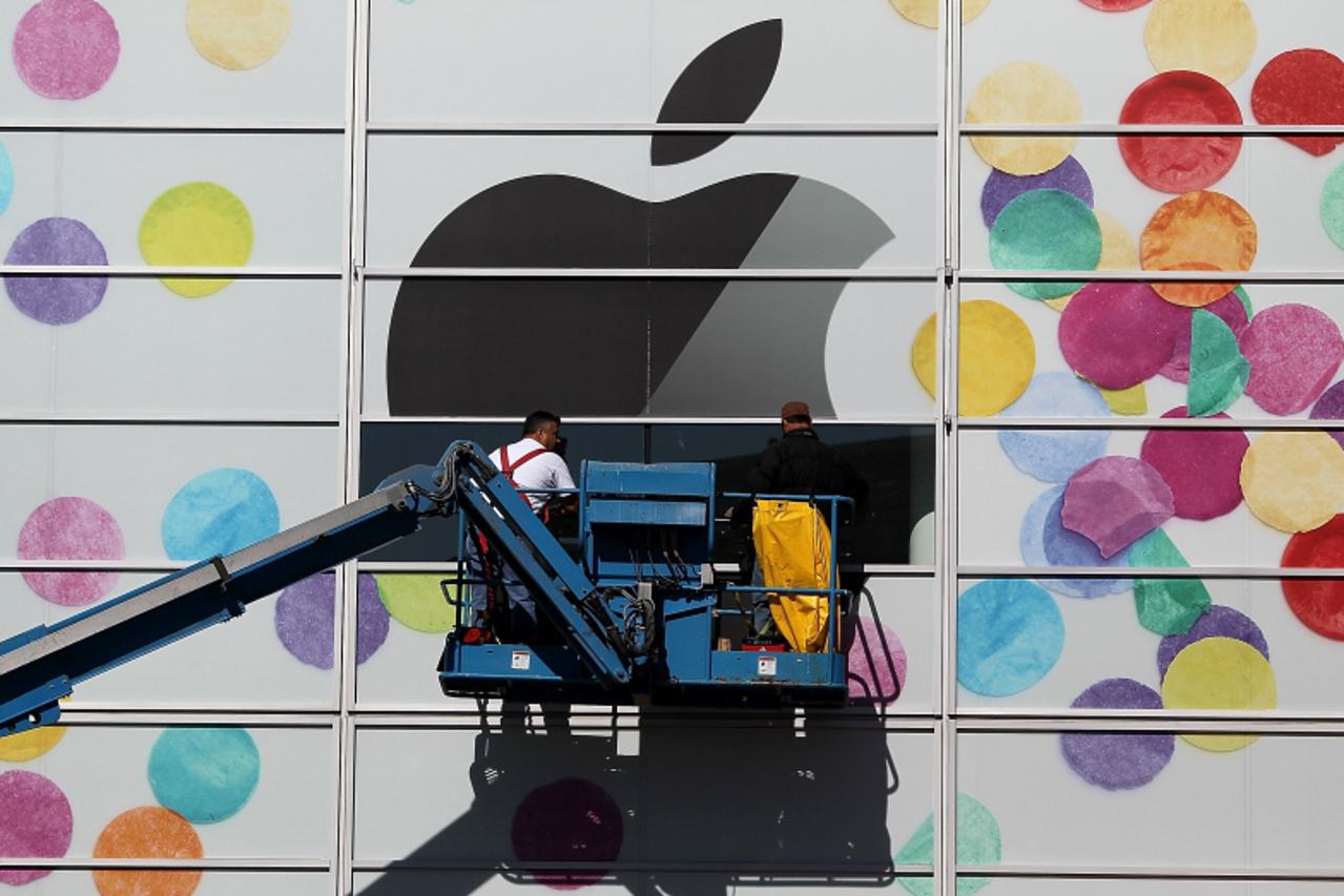 'SAN FRANCISCO, CA - FEBRUARY 28: Workers apply the Apple logo the outside of the Yerba Buena Center for the Arts on February 28, 2011 in San Francisco, California. Apple is preparing to launch the iP